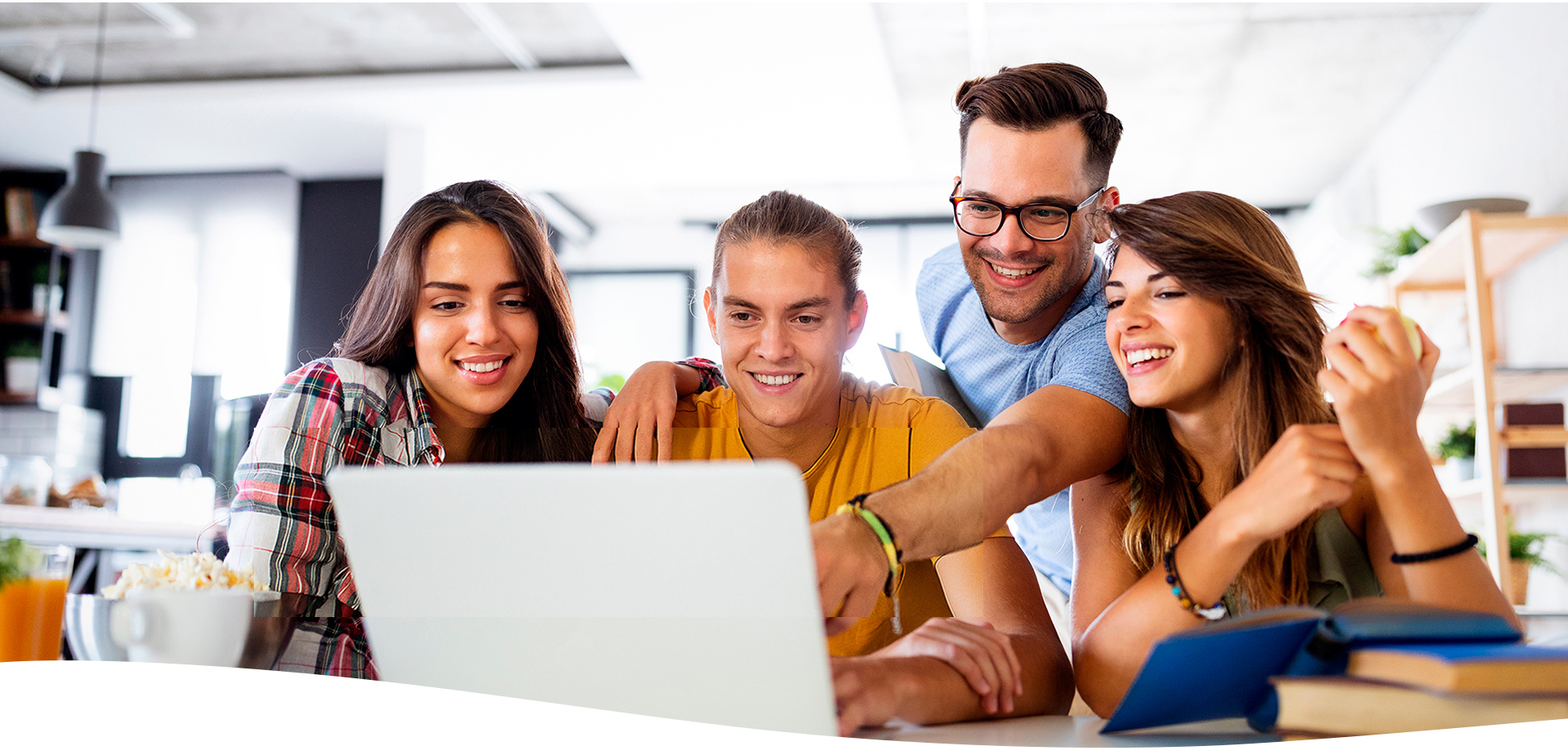 Jóvenes reunidos en la oficina y utilizando una computadora portátil